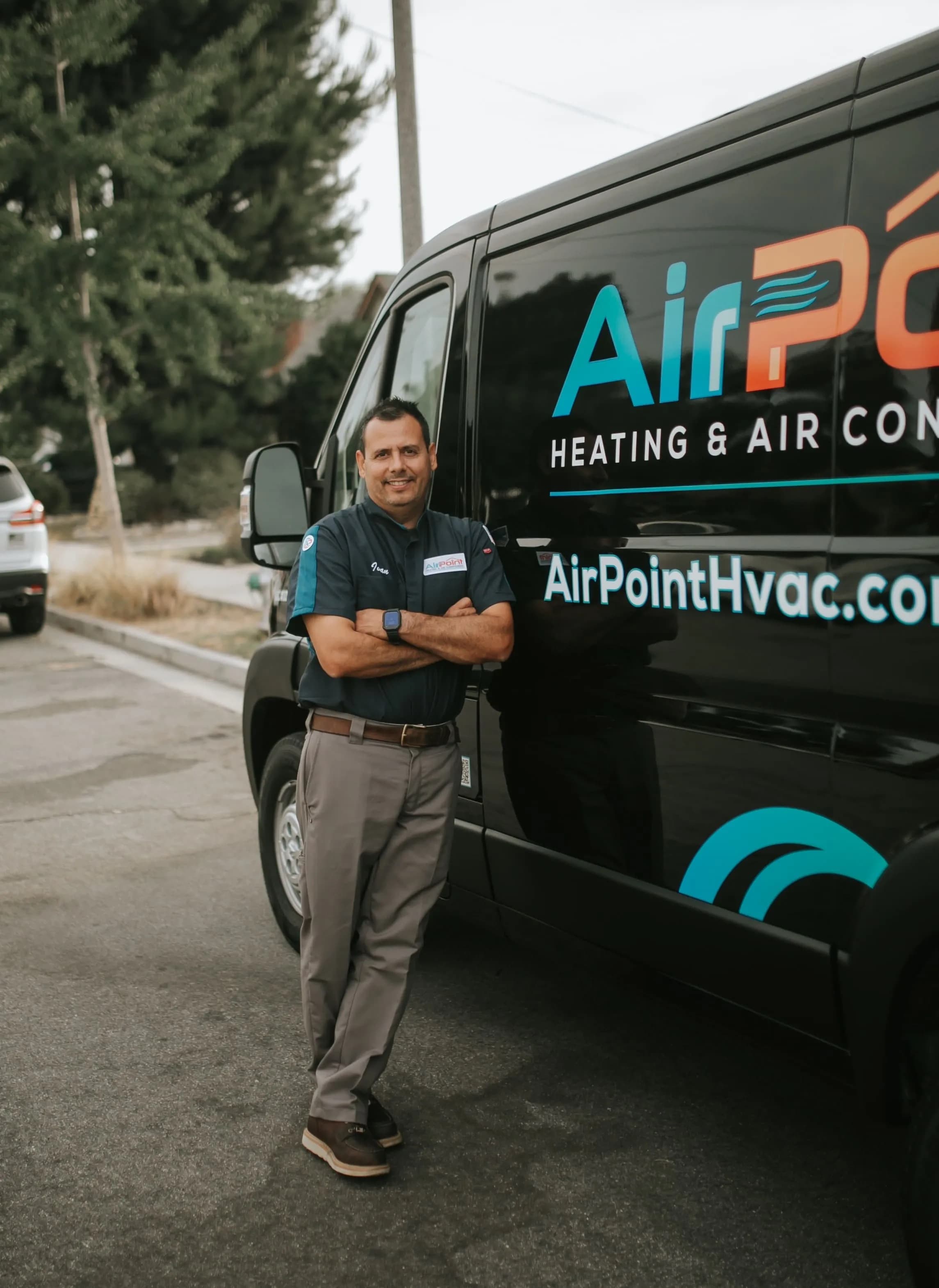 Daniel McGaven standing beside an AirPoint HVAC service van